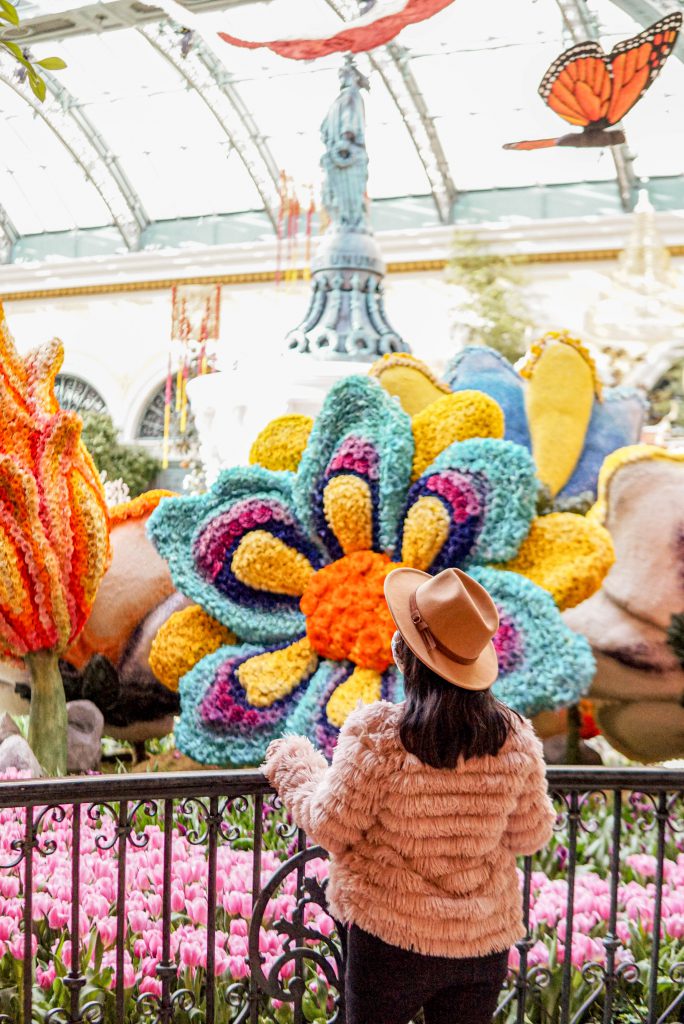 woman gazing at floral display at Bellagio conservatory