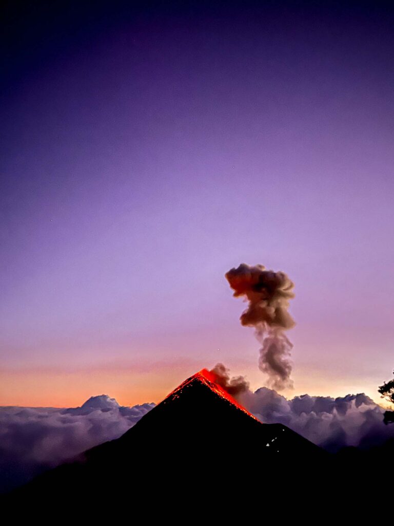 Volcan Fuego at sunset, with lava and smoke against a purple sky