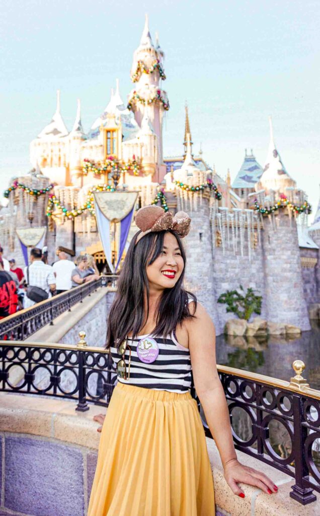 woman standing in front of Sleeping beauty castle