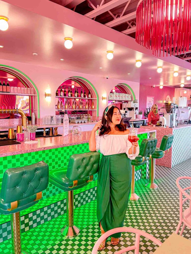 woman holding drink in front of bar area at coffee dose